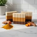Turmeric Bar Soap on marble surface with turmeric root and powder