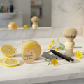 Men's loofah shave soap bar with straight razor, shaving brush and lemon slices on marble